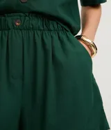 Short femenino de viscolino color blanco, modelo runner evasê, con cintura elástica, botón frontal y bolsillos laterales.