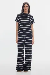 Pantalón de punto negro con rayas horizontales blancas, de calce recto y cintura elastizada.