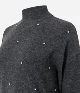 Suéter de punto negro con cuello medio, manga larga y diseño geométrico en relieve. Presenta una delicada aplicación de beads brillantes distribuidos en forma de rombos sobre el frente.