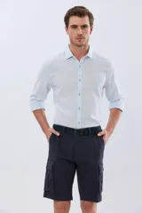 Bermuda cargo color azul marino, de gabardina con bolsillos laterales con solapa en las piernas y presillas para cinturón. Incluye cinturón de lona trenzada oscura con detalles en cuero sintético y hebilla metálica.