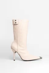 Bota de cuero color crema, con punta fina metálica y cierre lateral.