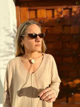 Buzo de tejido de punto color beige, de corte holgado y mangas largas.