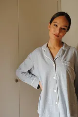 Conjunto de pijama de algodón gris con estampado geométrico blanco, compuesto por una camisa de manga larga con botones y un pantalón largo con elástico en la cintura.