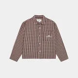 Camisa de manga larga con cuello camisero, corte boxy y estampado a cuadros en tonos marrón y blanco. Presenta un bolsillo frontal izquierdo con bordado blanco.