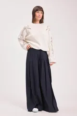 Sweater de punto color crudo, con diseño de calados decorativos en hombros y mangas, cuello redondo y corte holgado.