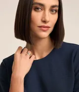 Blusa de tejido plano color azul marino, con cuello redondo, mangas cortas y cierre trasero tipo gota con botón.