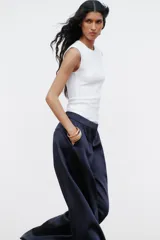 Top blanco de manga sisa con cuello redondo y corte ajustado al cuerpo.