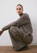 Pantalón de corte ancho, estilo relaxed, color gris topo, con cintura elástica ajustable mediante cordón.