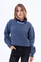 Buzo tejido de punto con diseño a rayas horizontales en tonos azul y celeste, de corte holgado, cuello redondo y mangas largas.