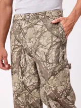 Pantalon recto de lona, color beige, con diseño de paneles reforzados en las piernas y cierre frontal con boton.