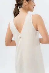 Vestido largo de lino con escote en V, diseño recto y fluido, con cierre frontal abotonado mediante botones de madera.