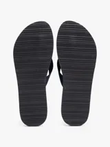 Ojotas de mujer color azul marino con tiras trenzadas de tela y una pequeña insignia metálica con el monograma TH en contraste sobre la tira del dedo. La plantilla presenta un patrón de eslabones blancos y finas líneas blancas.