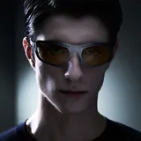 Lentes de sol envolventes con montura de acero inoxidable en color gunmetal y lentes de nylon amarillos. Presentan un diseño deportivo con aberturas decorativas en la parte superior del marco y patillas de acetato.