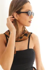 Lentes de sol negros con marco ovalado de policarbonato y protección UV400.