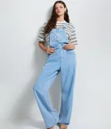 Peto de jean azul claro con corte recto, escote cuadrado, tirantes ajustables con hebillas metálicas y cierre lateral con botones. Cuenta con bolsillo frontal tipo parche y bolsillos laterales funcionales.