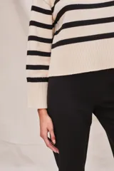 Polera de cuello alto, color blanco con rayas horizontales marrones. De calce ajustado y manga larga con puños acampanados.