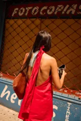 Minivestido rojo de lino con escote halter, espalda descubierta y detalle de flecos celestes en el ruedo.