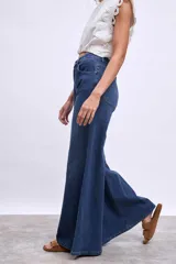 Pantalón de jean azul oscuro, modelo wide leg (pierna ancha) con tiro alto y cierre frontal de botones.