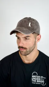 Gorra tipo baseball color gris con efecto desgastado y logo bordado en blanco en el frente.