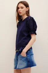 Remera fucsia con mangas abullonadas de broderie estilo globo, con cuello redondo y diseño liso en el cuerpo.
