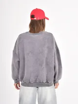 Buzo de cuello redondo y manga larga, con diseño holgado y efecto de lavado gastado.
