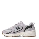 Championes New Balance 530 de estilo urbano, confeccionados en malla gris y superposiciones de gamuza en tono lila. Cuentan con detalles en negro, entresuela blanca ABZORB y suela de goma con tacos marrones.