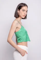 Top verde con estampado de hojas, breteles finos y escote en V.