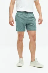 Short de baño liso con cintura elástica y cordón ajustable. Cuenta con dos bolsillos laterales, un bolsillo trasero y logo bordado en el ruedo. Confeccionado en tejido ligero de secado rápido.