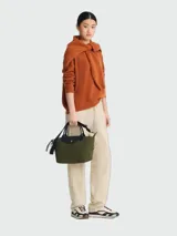 Cartera de mano modelo Le Pliage Energy tamaño S, confeccionada en lona resistente color verde oliva con detalles en cuero negro. Cuenta con cierre principal, solapa con botón a presión, doble asa corta y correa bandolera extraíble y ajustable.
