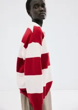 Sweater de punto con diseño de rayas horizontales rojas y blancas, cuello polo y escote en V.