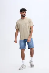 Remera de algodón color beige con fit regular, cuello redondo, mangas cortas y estampa circular en el pecho.