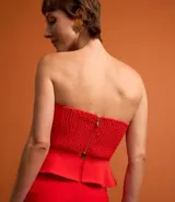 Blusa de sastrería color rojo vibrante, estilo palabra de honor con escote corazón y peplum (volado) en la cintura. La espalda cuenta con elástico para mejor ajuste y cierre trasero.