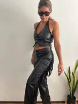 Pantalón negro de cuero sintético con flecos en los laterales.