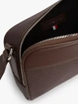Cartera bandolera Tommy Hilfiger de color marrón, con diseño texturizado, paneles combinados y motivo integral de logos en relieve. Cuenta con cierre de cremallera, compartimento principal y correa ajustable.