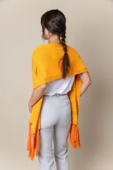 Chal de hilo artesanal color verde con detalles en gris y blanco, con flecos en los extremos y presilla para sujetarlo.