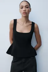 Top peplum blanco de manga sisa, con escote cuadrado y cierre de cremallera oculta en la espalda.