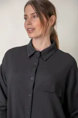 Camisa negra de crepe granulado con spandex, manga larga y corte holgado.