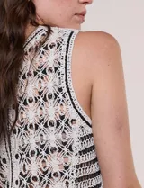 Chaleco de crochet color blanco con detalles en negro, escote en V y cierre frontal con botones.