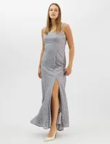 Vestido largo de encaje color beige, con escote recto decorado con pedrería y perlas, tirantes anchos y tajo lateral en la falda.