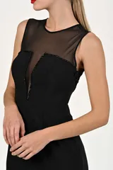 Vestido midi negro con escote transparente y detalle de lentejuelas en el borde del escote.