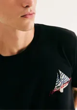 Camiseta blanca de algodón con cuello redondo y mangas cortas. Estampa rectangular con borde negro que contiene la frase "NATURAL ATMOSPHERE" en letras mayúsculas y una imagen de montañas y mar.