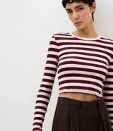 Blusa cropped Blue Steel de manga larga y cuello redondo, confeccionada en ribana con diseño a rayas horizontales en tonos bordó y rosado.