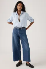 Jeans de mezclilla azul con diseño wide leg, tiro medio y corte al tobillo.