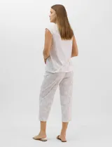 Pijama compuesto por remera sin mangas con escote redondo, botones frontales y detalle de puntilla, acompañado de un pantalón capri con cintura elástica. Presenta un estampado floral en tonos rosados sobre base gris.
