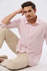 Pantalón de lino color beige, de corte recto y cintura elastizada con presillas para cinturón y bolsillos laterales.