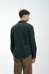 Camisa de manga larga azul de pana fina 100% algodón, con bolsillo en el pecho, botones blancos y calce clásico.