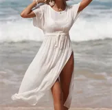 Vestido blanco de playa con mangas cortas y aberturas laterales.