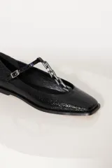 Ballerinas negras de cuero vacuno graneado con cadena metálica sobre el empeine y hebilla lateral.