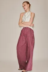 Pantalón de tiro medio color bordó con diseño de rayas verticales finas en tono claro. Presenta corte holgado, bolsillos laterales y cintura ajustable con cordón para atar.