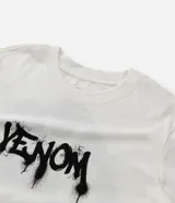 Remera blanca de corte regular, confeccionada en algodón, con cuello redondo, mangas cortas y estampa frontal en color negro con lettering estilo graffiti de Venom.